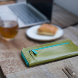 緑のL字ファスナー長財布がカフェに置いてある様子