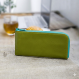 緑のL字ファスナー長財布がカフェのテーブルに置いてある様子