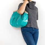 青い総革の軽量トートバッグを持つ女性